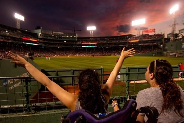 Fan cheers as the sun sets during a game between the Boston Red Sox and the Houston Astros on June 9, 2021 at Fenway Park in Boston, Massachusetts.