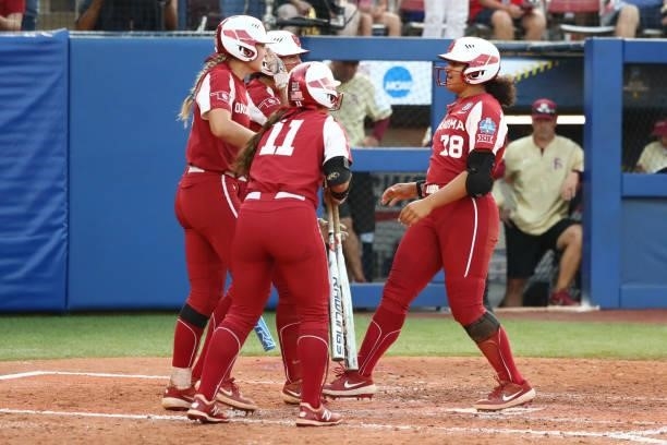 Jocelyn Alo of the Oklahoma Sooners celebrates with her teammates after hitting a two-run home run against the Florida St. Seminoles during the...