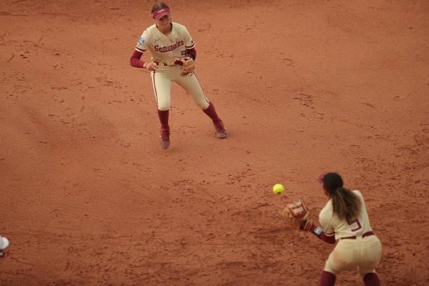 Devyn Flaherty of the Florida St. Seminoles makes a pass to Elizabeth Mason of the Florida St. Seminoles to make the play at first during the...