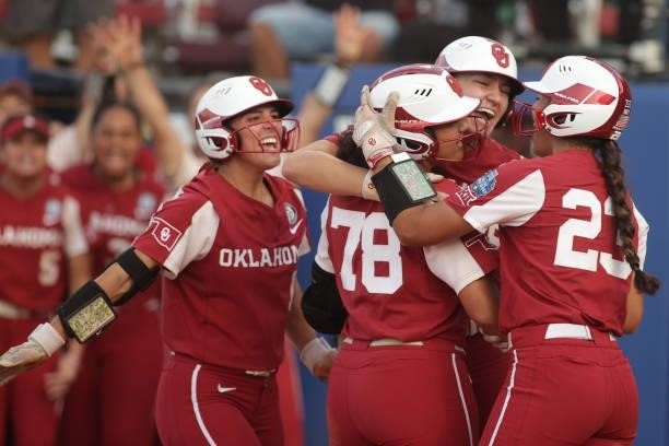 Jocelyn Alo of the Oklahoma Sooners is greeted at home plate by her teammates Kinzie Hansen and Tiare Jennings after hitting a home run during the...
