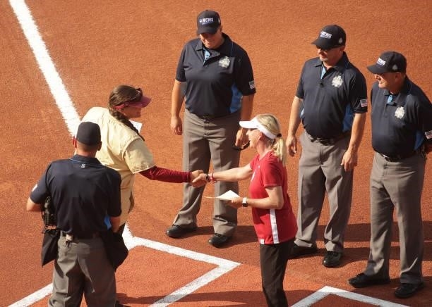 Head coach Lonni Alameda of the Florida St. Seminoles shakes hands with head coach Patty Gasso of the Oklahoma Sooners at home plate during the...