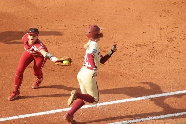 Taylon Snow of the Oklahoma Sooners misses a tag at first on Sydney Sherrill of the Florida St. Seminoles during the Division I Women's Softball...