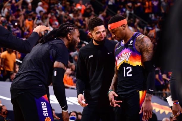 Jae Crowder and Devin Booker talk with Torrey Craig of the Phoenix Suns during Round 2, Game 2 of the 2021 NBA Playoffs on June 9, 2021 at Phoenix...