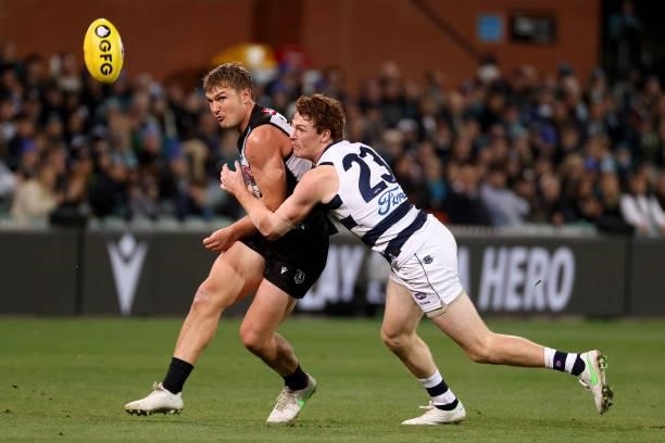 Ollie Wines of the Power is tackled by Gary Rohan of the Cats during the 2021 AFL Round 13 match between the Port Adelaide Power and the Geelong Cats...