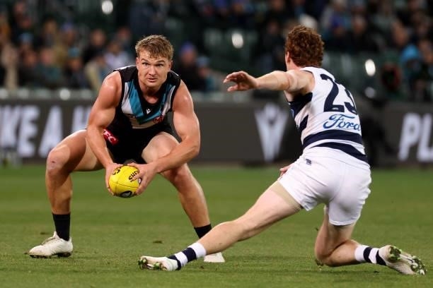 Ollie Wines of the Power is tackled by Gary Rohan of the Cats during the 2021 AFL Round 13 match between the Port Adelaide Power and the Geelong Cats...