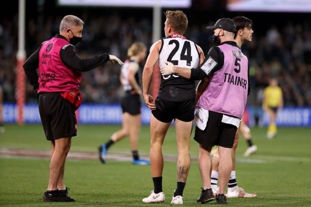 Kane Farrell of the Power goes off injured during the 2021 AFL Round 13 match between the Port Adelaide Power and the Geelong Cats at Adelaide Oval...