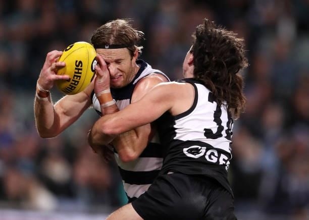 Lachie Henderson of the Cats under pressure from Lachlan Jones of the Power during the 2021 AFL Round 13 match between the Port Adelaide Power and...