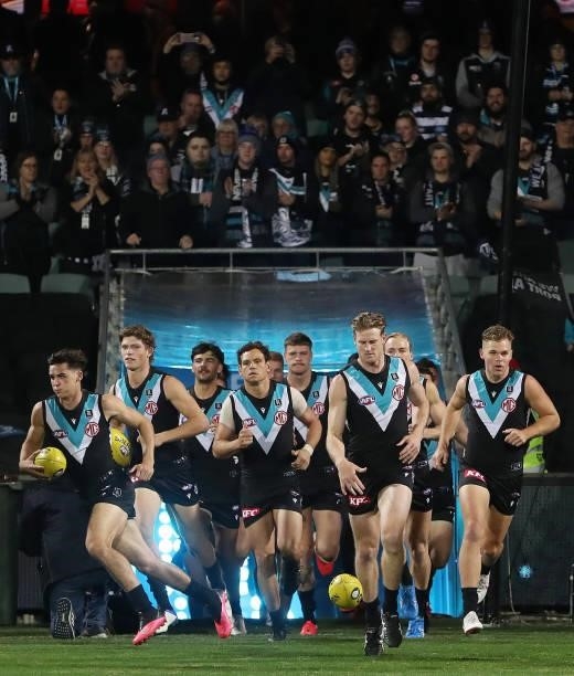 Tom Jonas of the Power leads his team out onto the oval during the 2021 AFL Round 13 match between the Port Adelaide Power and the Geelong Cats at...