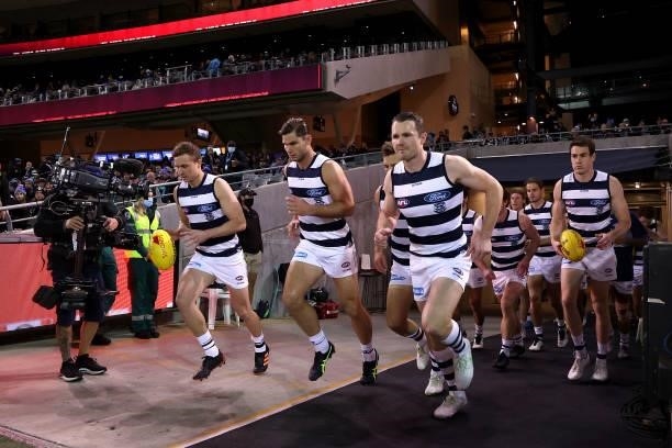 The Cats run out during the 2021 AFL Round 13 match between the Port Adelaide Power and the Geelong Cats at Adelaide Oval on June 10, 2021 in...