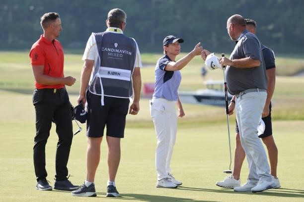 Thomas Bjorn of Denmark reacts to Annika Sorenstam of Sweden on the 18th green during the first round of The Scandinavian Mixed Hosted by Henrik and...