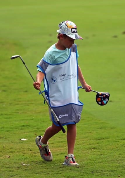 Young caddie carries a couple of clubs on the 12th hole during the first round of the BMW Charity Pro-Am presented by Synnex Corporation at the...