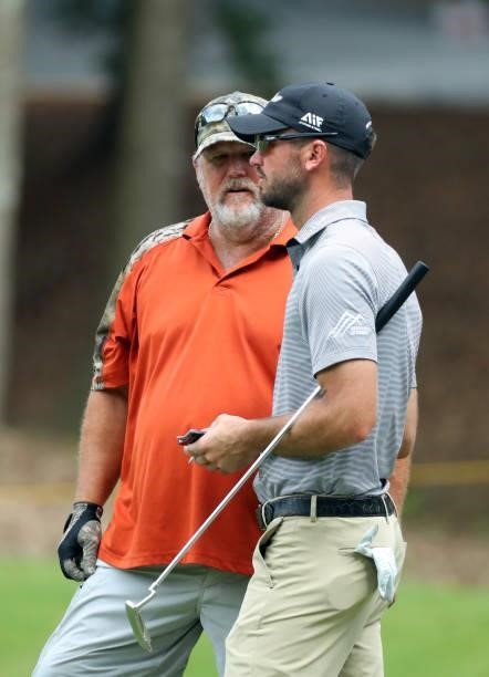 Brandon Crick speaks with his playing partner with Larry the Cable Guy on the fourth hole during the first round of the BMW Charity Pro-Am presented...