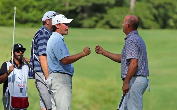 Michael Miller and playing partner Matt Minerva fist bump after making birdie on the fourth hole during the first round of the BMW Charity Pro-Am...