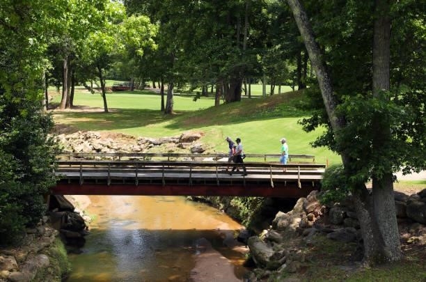 Players walk on the bridge over the creek on the first hole during the first round of the BMW Charity Pro-Am presented by Synnex Corporation at the...