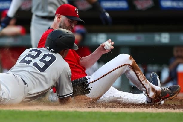 Happ of the Minnesota Twins tags out Gio Urshela of the New York Yankees at home plate in the first inning of the game at Target Field on June 10,...
