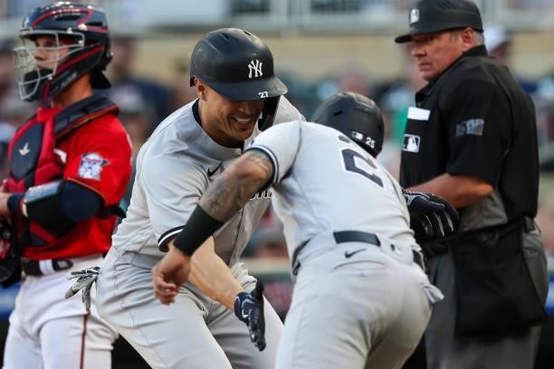 Giancarlo Stanton celebrates with Gleyber Torres of the New York Yankees after hitting a three-run home run against the Minnesota Twins in the first...