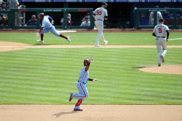 Odúbel Herrera of the Philadelphia Phillies runs to home for the winning run as Jean Segura runs to second for a double during the game between the...