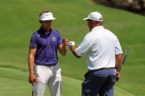 James Nicholas and Dr. Stephen Nicholas fist bump on the ninth hole during the second round of the BMW Charity Pro-Am presented by Synnex Corporation...