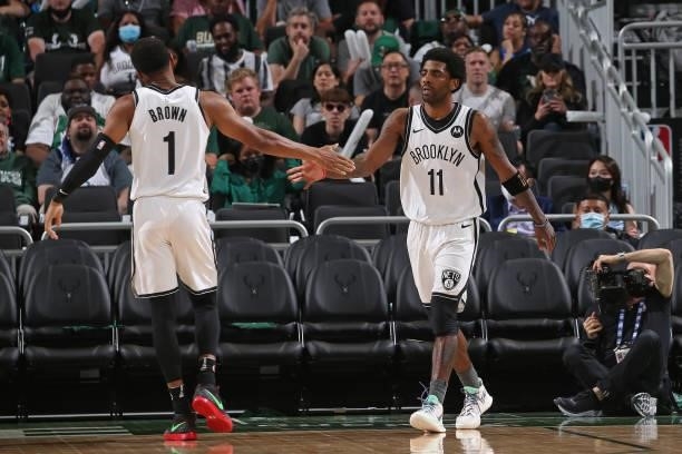Kyrie Irving hi-fives Bruce Brown of the Brooklyn Nets during Round 2, Game 3 of the 2021 NBA Playoffs on June 10, 2021 at the Fiserv Forum Center in...