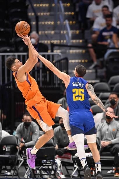 Devin Booker of the Phoenix Suns shoots under coverage by Austin Rivers of the Denver Nuggets in Game Three of the Western Conference second-round...