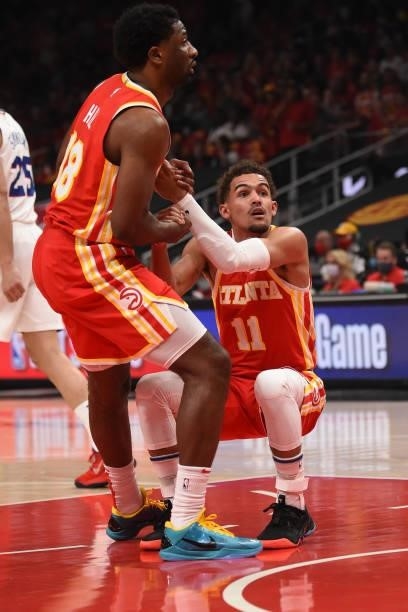Solomon Hill of the Atlanta Hawks helps up Trae Young of the Atlanta Hawks during Round 2, Game 3 of the Eastern Conference Playoffs on June 11, 2021...