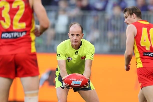Umpire Dean Margetts throws the ball up during the 2021 AFL Round 13 match between the Fremantle Dockers and the Gold Coast Suns at Optus Stadium on...