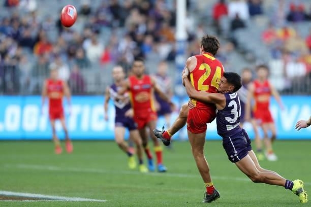 David Swallow of the Suns is tackled by Brandon Walker of the Dockers during the 2021 AFL Round 13 match between the Fremantle Dockers and the Gold...