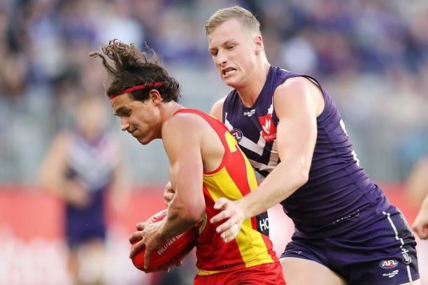 Wil Powell of the Suns is tackled by Josh Treacy of the Dockers during the 2021 AFL Round 13 match between the Fremantle Dockers and the Gold Coast...