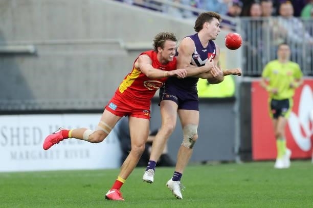 Sam Sturt of the Dockers is tackled by Charlie Ballard of the Suns during the 2021 AFL Round 13 match between the Fremantle Dockers and the Gold...