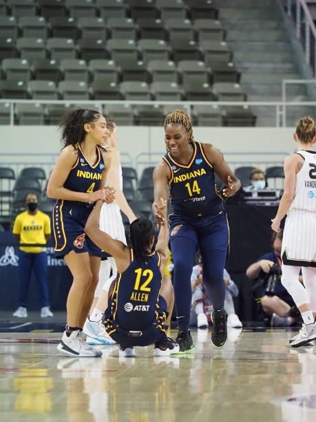 Kysre Gondrezick of the Indiana Fever and Jantel Lavender of the Indiana Fever help up Lindsay Allen of the Indiana Fever during the game against the...