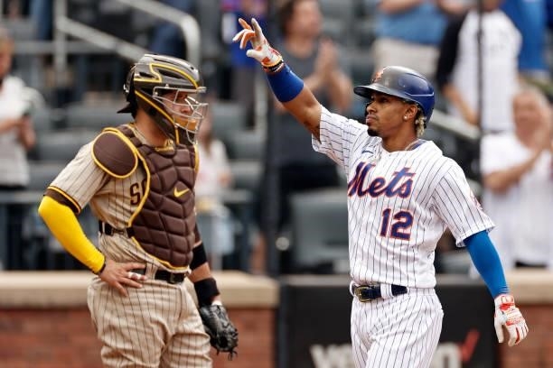 Francisco Lindor of the New York Mets celebrates hitting a 2-run home run in front of Victor Caratini of the San Diego Padres during the first inning...