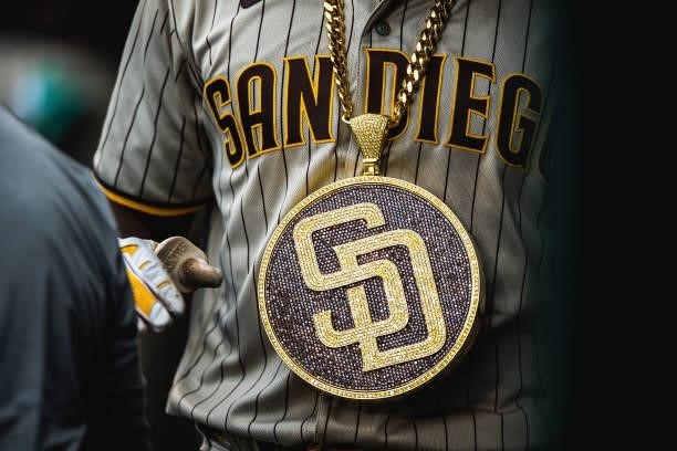 Fernando Tatis Jr of the San Diego Padres walks through the dugout with the 'swag chain' after hitting a home run in the seventh inning against the...