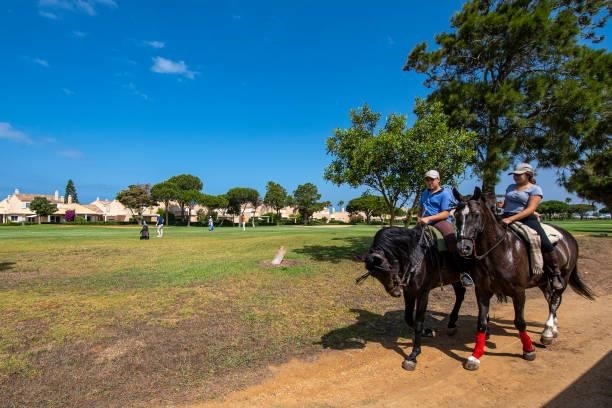 People ride by on horses as players play on the first hole during Day Four of the Challenge de Cadiz at Iberostar Real Club de Golf Novo Sancti Petri...