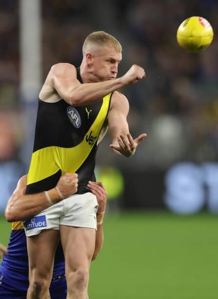 Josh Caddy of the Tigers handpasses the ball under pressure during the 2021 AFL Round 13 match between the West Coast Eagles and the Richmond Tigers...