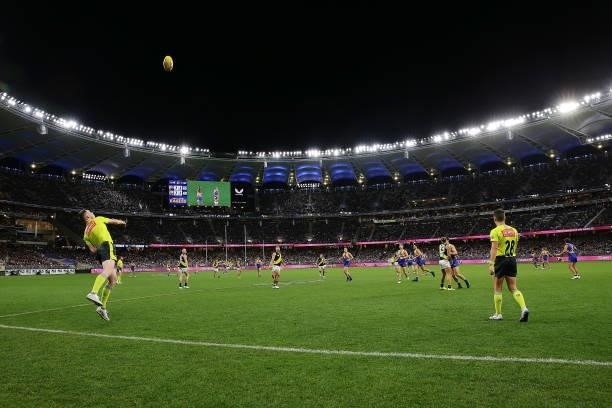 The boundary umpire throws the ball into play during the 2021 AFL Round 13 match between the West Coast Eagles and the Richmond Tigers at Optus...