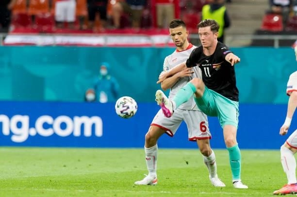 Visar Musliu of North Macedonia and Michael Gregoritsch of Austria battle for the ball during the UEFA Euro 2020 Championship Group C match between...