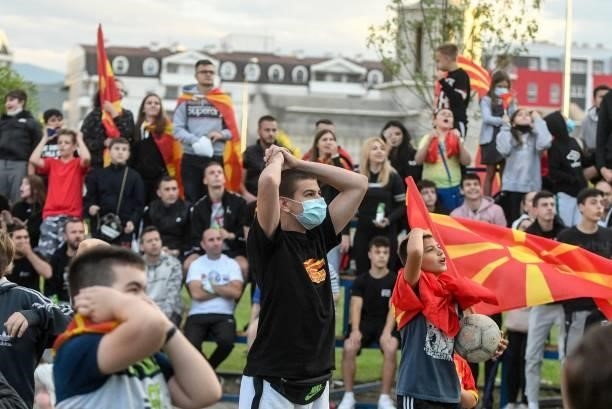 North Macedonia's supporters react as they watch the UEFA EURO 2020 Group C football match between Austria and North Macedonia in downtown Skopje on...