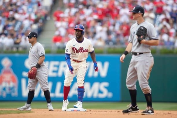 Andrew McCutchen of the Philadelphia Phillies reacts in front of Rougned Odor and DJ LeMahieu of the New York Yankees after hitting a two RBI double...