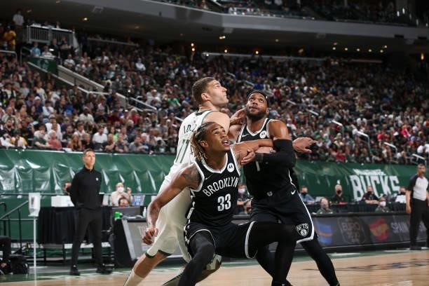 Nicolas Claxton of the Brooklyn Nets, Brook Lopez of the Milwaukee Bucks and Bruce Brown of the Brooklyn Nets fight for position during the game...