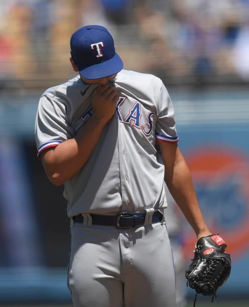 Starting pitcher Dane Dunning of the Texas Rangers reacts after giving up a run to the Los Angeles Dodgers during the first inning of their...