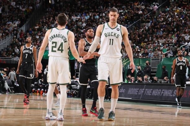 Brook Lopez of the Milwaukee Bucks high fives Pat Connaughton of the Milwaukee Bucks during Round 2, Game 4 of the 2021 NBA Playoffs on June 13 2021...
