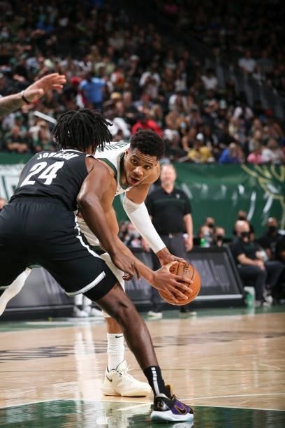 Giannis Antetokounmpo of the Milwaukee Bucks handles the ball during the game as Alize Johnson of the Brooklyn Nets plays defense during Round 2,...