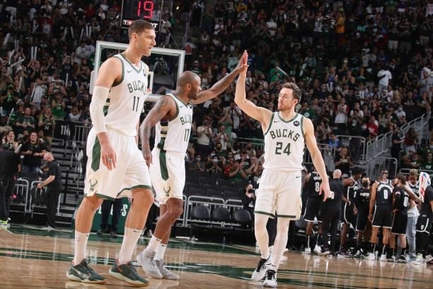 Tucker of the Milwaukee Bucks high fives Pat Connaughton of the Milwaukee Bucks during Round 2, Game 4 of the 2021 NBA Playoffs on June 13 2021 at...