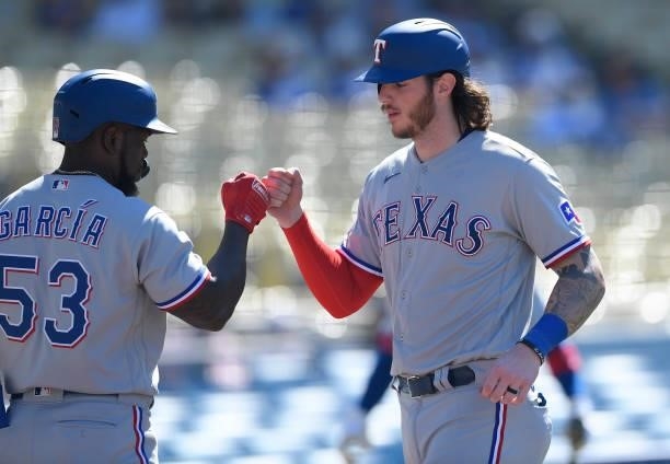Jonah Heim of the Texas Rangers celebrates with Adolis Garcia after spring a run against the Los Angeles Dodgers during the ninth inning of a...