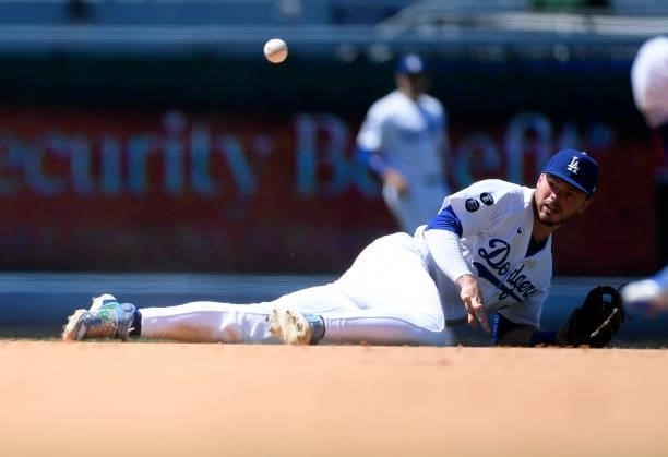 Gavin Lux of the Los Angeles Dodgers throws to second base after making a diving catch on a grounder by Brock Holt of the Texas Rangers and throwing...