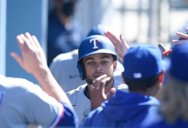 Jason Martin of the Texas Rangers is congratulated in the dugout after scoring a run against Los Angeles Dodgers during the ninth inning of a...
