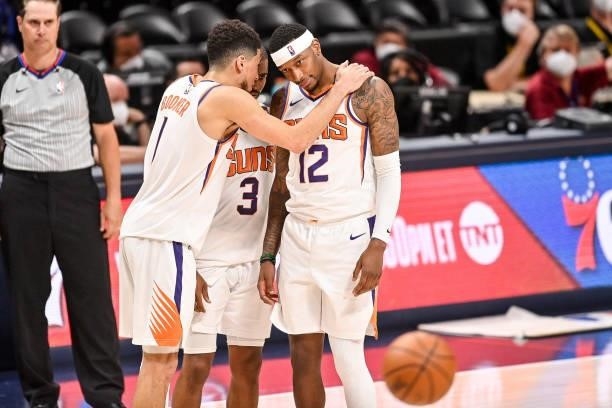 Devin Booker, Chris Paul and Torrey Craig of the Phoenix Suns huddle late in the fourth quarter against the Denver Nuggets in Game Four of the...