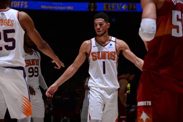 Devin Booker of the Phoenix Suns high fives his teammates during Round 2, Game 4 of the 2021 NBA Playoffs on June 13, 2021 at the Ball Arena in...