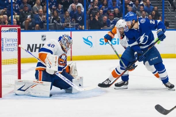 Brayden Point of the Tampa Bay Lightning shoots the puck against goalie Semyon Varlamov and Adam Pelech of the New York Islanders during the first...
