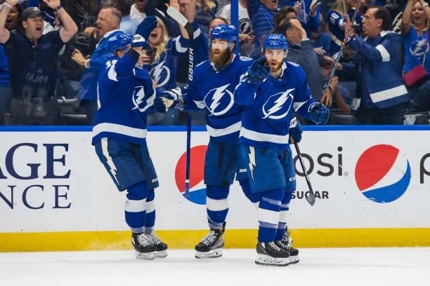 Brayden Point of the Tampa Bay Lightning celebrates a goal with teammates Ondrej Palat and David Savard against the New York Islanders during the...